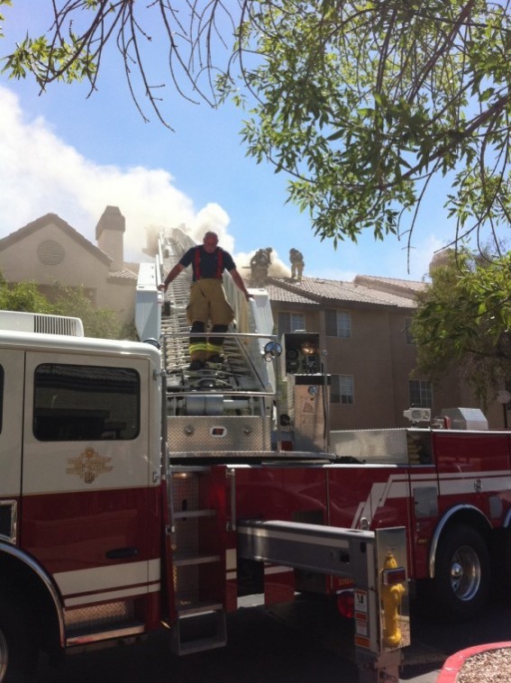 A firefighter climbs down the ladder as others battle the third story apartment fire.