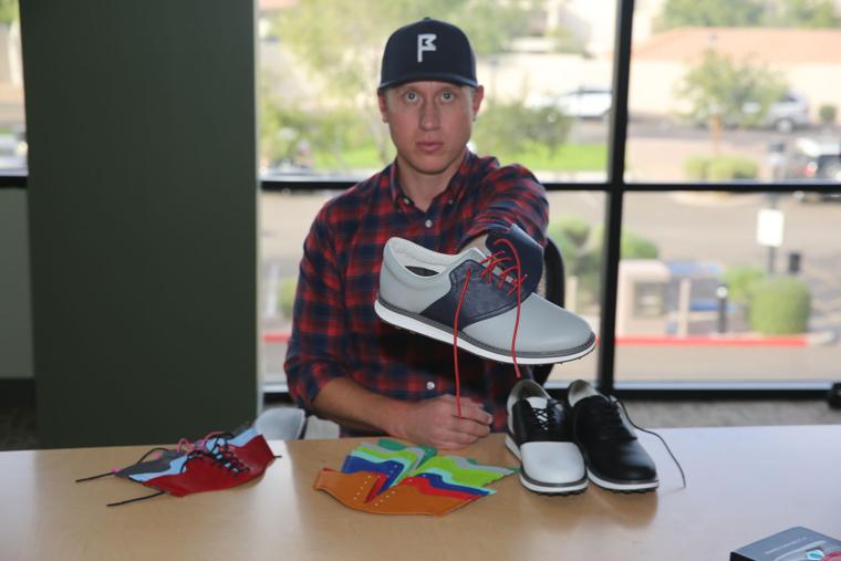 Bart Walker of Ahwatukee holds the golf shoe he designed