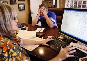 <p>Colin Turn of Oklahoma City reacts to the news that he and his wife will owe additional taxes this year after Vickie Eubanks, co-owner of Eubanks Tax Service in Del City, filed his state and federal tax returns Monday afternoon. Turn said he wasn't really surprised by the bad news. He said "it can always go either way." Turn said he waited until the last minute to file his taxes because he works two jobs and is "very busy." He admitted to being a procrastinator this year. Turn was among many last-minute taxpayers who wait until the final day to prepare their taxes to meet the midnight deadline on Monday, April 15, 2013. (AP Photo/The Oklahoman, Jim Beckel)</p>
