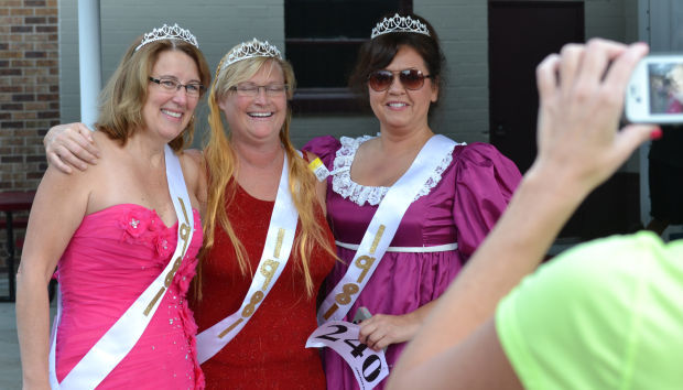 Michelle Reed, left, Kris Westlake and Cheryl Chappelear pose for a photo prior to Saturday's Dash for the Sash in Arlington. The fundraiser for Arlington's post-prom party encourages participants to run or walk in prom attire.