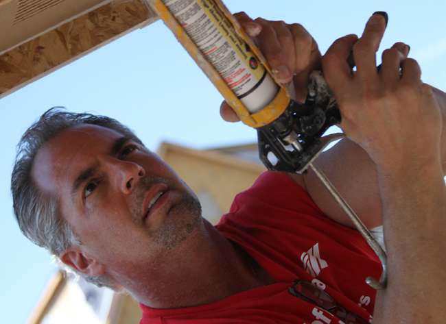 Don Wratchford of Kansas City preps the #3 Habitat for Humanity house for paint Friday afternoon at 2209 Kentucky. Wratchford came with a group from Merrill ... - 53cdd61a04f92.image