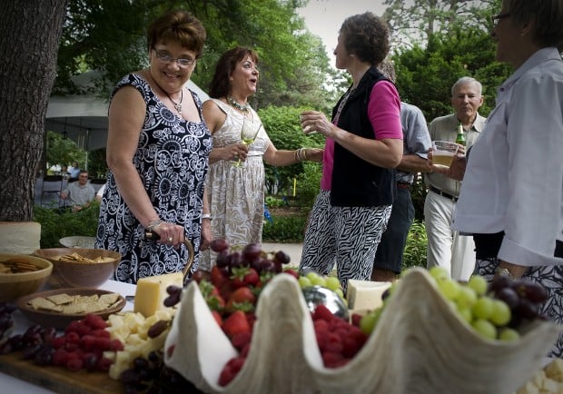 Deb Arends middle talks with guests during a backyard wedding reception 