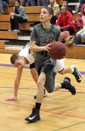 Boys Basketball: Hawks Outlast Falcons In Overtime, Advance To Section Championship : Zack Justice of the Liberty Ranch Hawks heads for the paint as a Colfax Falcons defender gets tripped up at Tokay High School on Wednesday, Feb. 27, 2013. The Hawks beat the Falcons 64-59 in overtime to advance to the Sac-Joaquin Section Division IV championship against the Summerville Bears of Tuolumne at Sleep Train Arena in Sacramento on Saturday, March 2, 2013.
 - Photo by Jerry R. Tyson/News-Sentinel