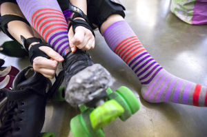 Reporter Skates After Her Derby Girl Dreams : News-Sentinel reporter Sara Jane Pohlman laces up her roller skate before practicing with the Port City Roller Girls roller derby team at the San Joaquin County Fairgrounds on Thursday, Feb. 7, 2013.
 - Photo by Dan Evans/News-Sentinel