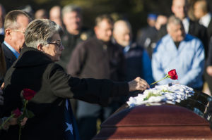 Fallen Galt Police Officer Kevin Tonn Laid To Rest : Maryann Tonn, Galt Police Officer Kevin Tonn’s mother, places a rose on his casket during the graveside service on Monday, Jan. 21, 2013.
 - Photo by Dan Evans/News-Sentinel