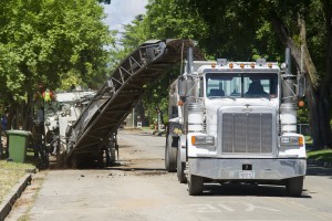 Asphalt grinder tears up road for water main project