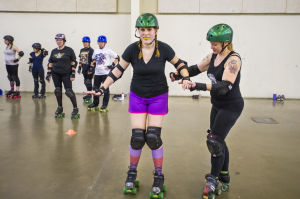 Reporter Skates After Her Derby Girl Dreams : “Malice,” right, helps News-Sentinel reporter Sara Jane Pohlman balance while practicing stops.
 - Photo by Dan Evans/News-Sentinel