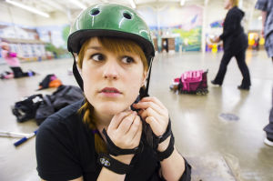 Reporter Skates After Her Derby Girl Dreams : News-Sentinel reporter Sara Jane Pohlman puts on an ill-fitting helmet before taking to the rink with the Port City Roller Girls roller derby team at the San Joaquin County Fairgrounds on Thursday, Feb. 7, 2013.
 - Photo by Dan Evans/News-Sentinel