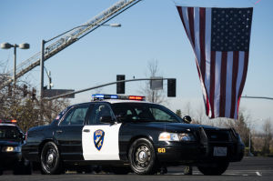Fallen Galt Police Officer Kevin Tonn Laid To Rest : A Galt police car passes by a large flag at the entrance of Adventure Community Church where the funeral for Officer Kevin Tonn was held on Monday, Jan. 21, 2013.
 - Photo by Dan Evans/News-Sentinel