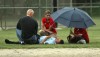 Umpire Steve Cox waits for an ambulance after injuring his hamstring Tuesday in the Class 4A Portage Regional championship.