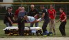 Umpire Steve Cox is taken to an awaiting ambulance after injuring his hamstring at Tuesday's Class 4A Portage Regional championship.