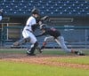 Washington Twp.'s Ryan Geberin dives under Kouts catcher Stefan Roney's tag