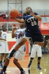 Michigan City senior forward Jameka Collins drives past Merrillville senior guard Darian Patton