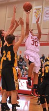 Hebron's Tony Rose pulls up for a jumper over a pair of Kouts defenders Friday night.