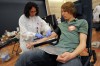 Nursing assistant draws blood from patient