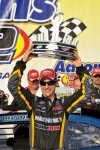 Joey Logano hoists the trophy in victory lane
