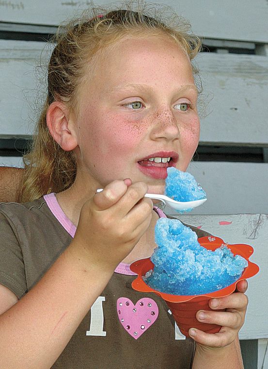 Melissa Carlo/The Courier Hunter Vititoe, 8, of Eldon enjoys a cool treat while watching harness racing at the Wapello County Fair Thursday afternoon. - 53d5d27a0b93a.image