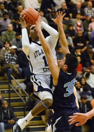 Top-ranked Atlantic City Grinds Way Past No. 3 Prep: Isiah Graves leaps to take a shot for the Vikings over St. Augustine Prep’s Joe Gatto during their Battle by the Bay game Friday night in Atlantic City.
