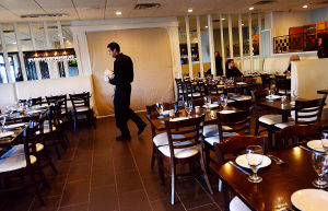 Tale Of Two Restaurants: Server Nick DeVito, of Margate, walks past the blocked-off entryway to the new under-construction area inside the original Johnny's Cafe in Margate, which is expanding in both directions while neighboring restaurant Fedeli's, a staple in town for decades, is permanently closed.
 - Photo by Ben Fogletto
