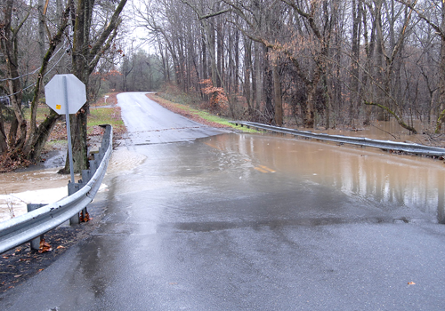 <p>Water from an overflowing creek covers Three Bridge Branch Road
at Old Skipton Road near Cordova as heavy rains soak the Mid-Shore
on Wednesday.</p>
