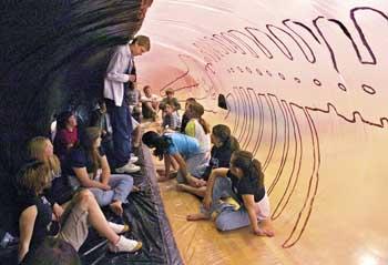 Photo from the Longview Daily News: Wahkiakum High School junior Mike Weiler talks with J.A. Wendt Elementary students about his
	 life-sized inflatable whale Tuesday. Throughout the day, Weiler invited students inside the creature for a presentation about
	  humpback whales, how they feed and where they live.