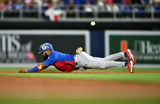 Dominican's outfielder #1 Emilio Bonifacio dives to second base  during the Caribbean Series baseball game between the Dominican Republic and Puerto Rico at LoanDepot Park in Miami, Florida, on February 3, 2024.