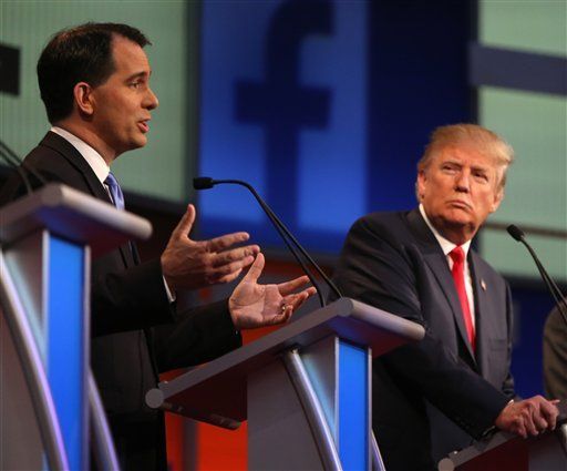 Scott Walker speaks while Donald Trump looks on