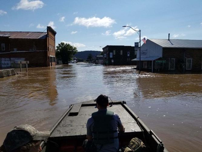 Nick Webster operates a boat while fellow Recreation Warden Jake Holsclaw watches for debris
