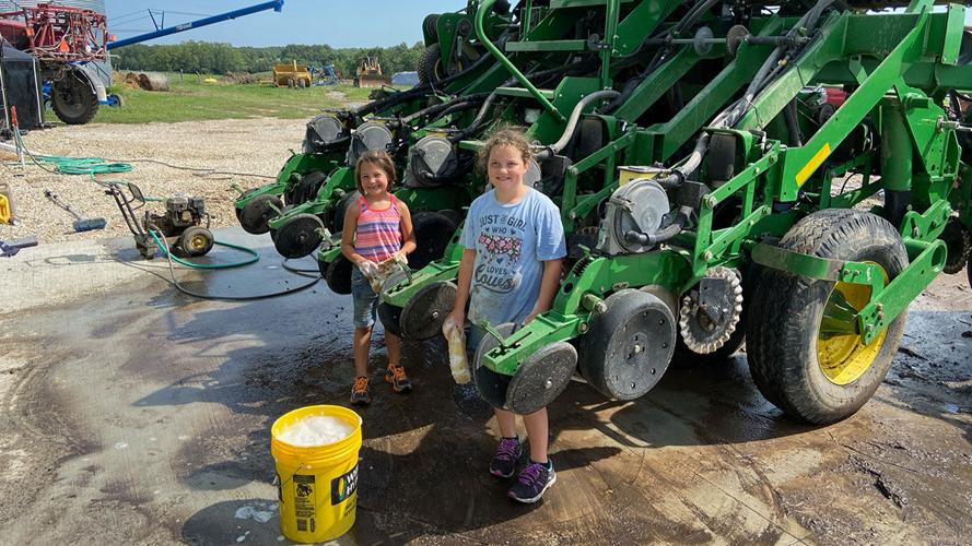 Abigail and Elisabeth Wright help clean a planter.