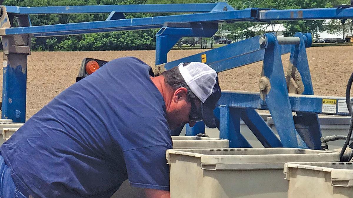 Kelly Robertson checks seed in a planter