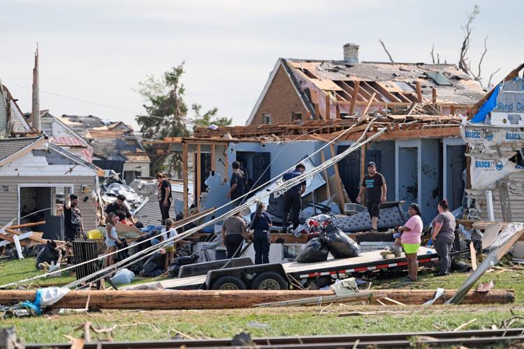 People look over a destroyed home following severe weather, including a tornado Monday, July 27, 2026, in Menasha, Wisconsin.