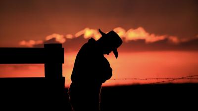 Farmer rancher against sunset