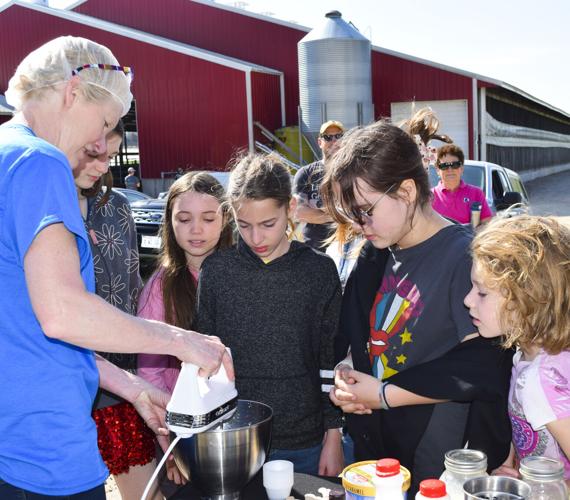 Connie Valenza showing Girl Scouts how to make whipping cream