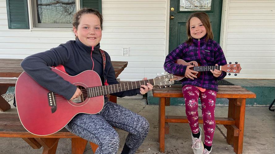 Abigail and Elisabeth Wright practice playing their instruments