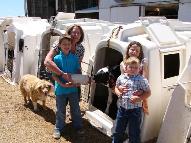 Terry Bernick and grandkids feed calf