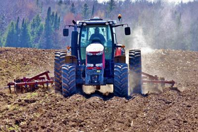 Sam Zimmerman of Ringle, Wisconsin, does field cultivating with tractor