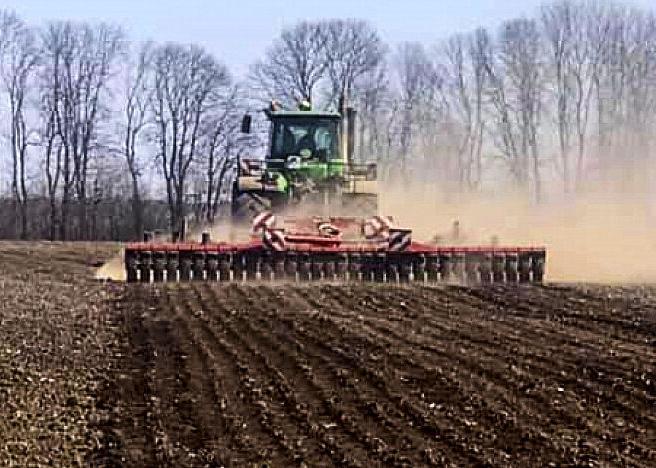 Tractor tills in field