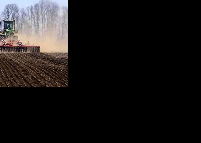 Tractor tills in field