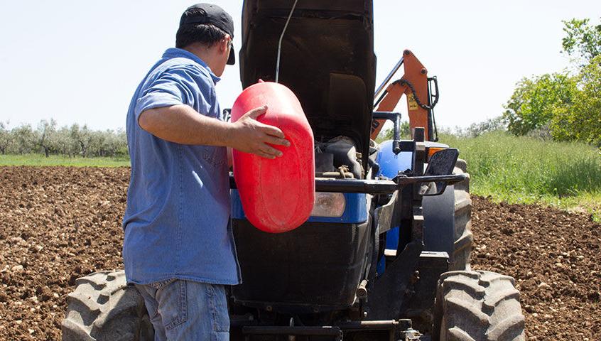 Farmer puts diesel fuel to the tractor