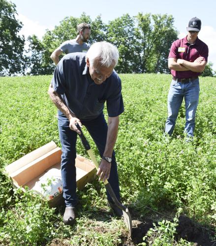 Gary Zimmer digs ground to show soil sample