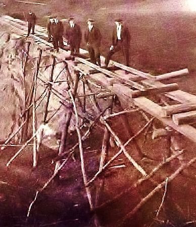 Crew stands on railroad bridge