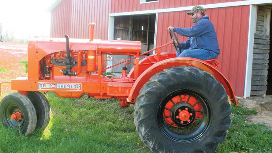 Mark Medford climbs onto an antique tractor