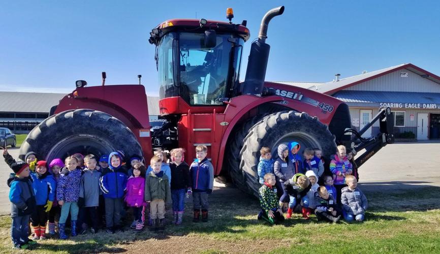 Kids stand by tractor