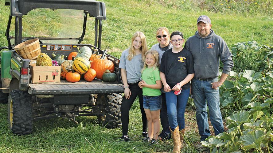 Schaer family poses with the pumpkin display