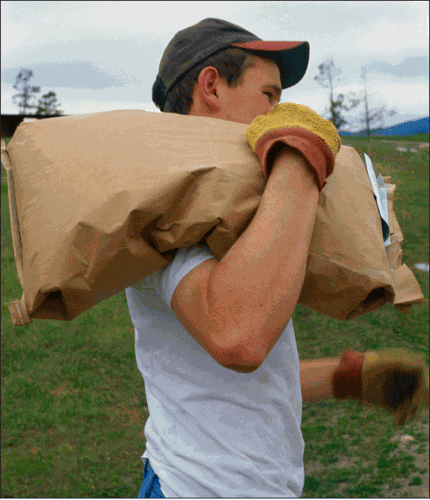 guy carrying bag of seed