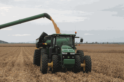 harvest field tractor receiving corn