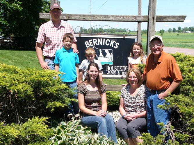 Family by farm sign