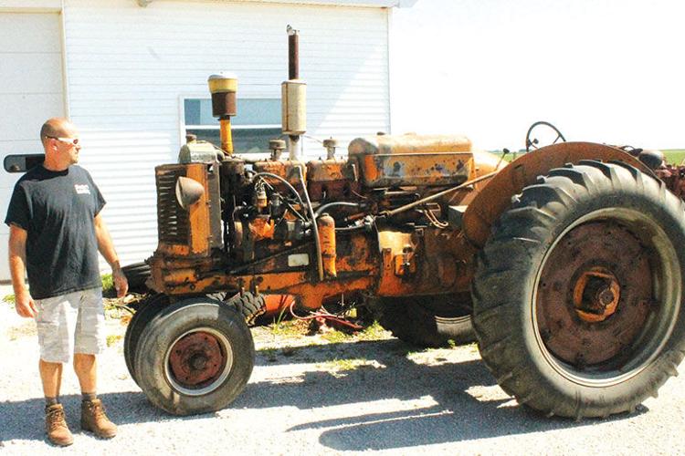 Shuster looks at a tractor