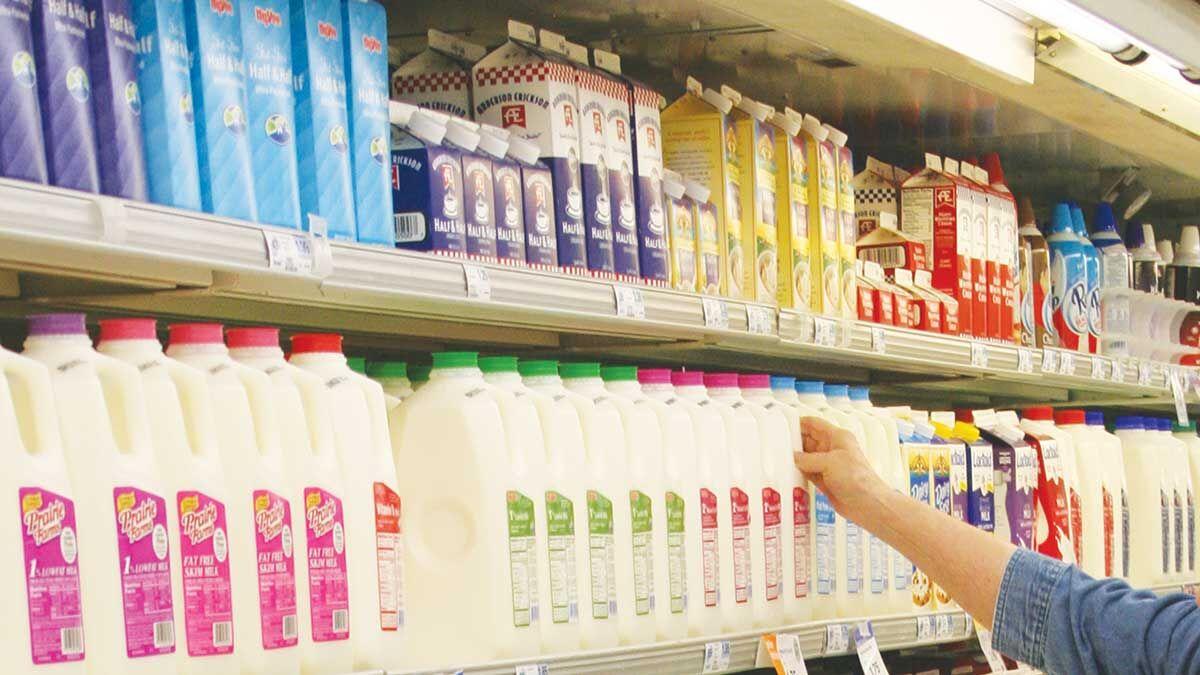 Dairy product on store shelf with hand reaching