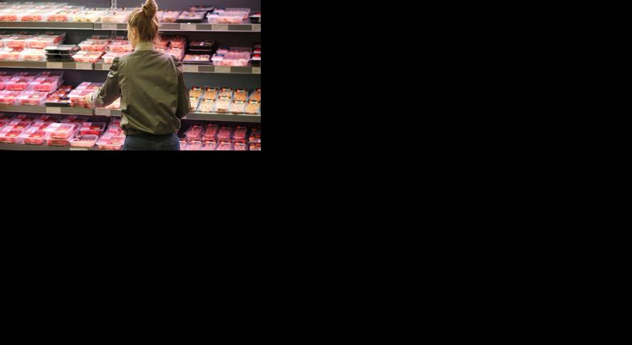 Woman purchasing a packet of meat at the supermarket